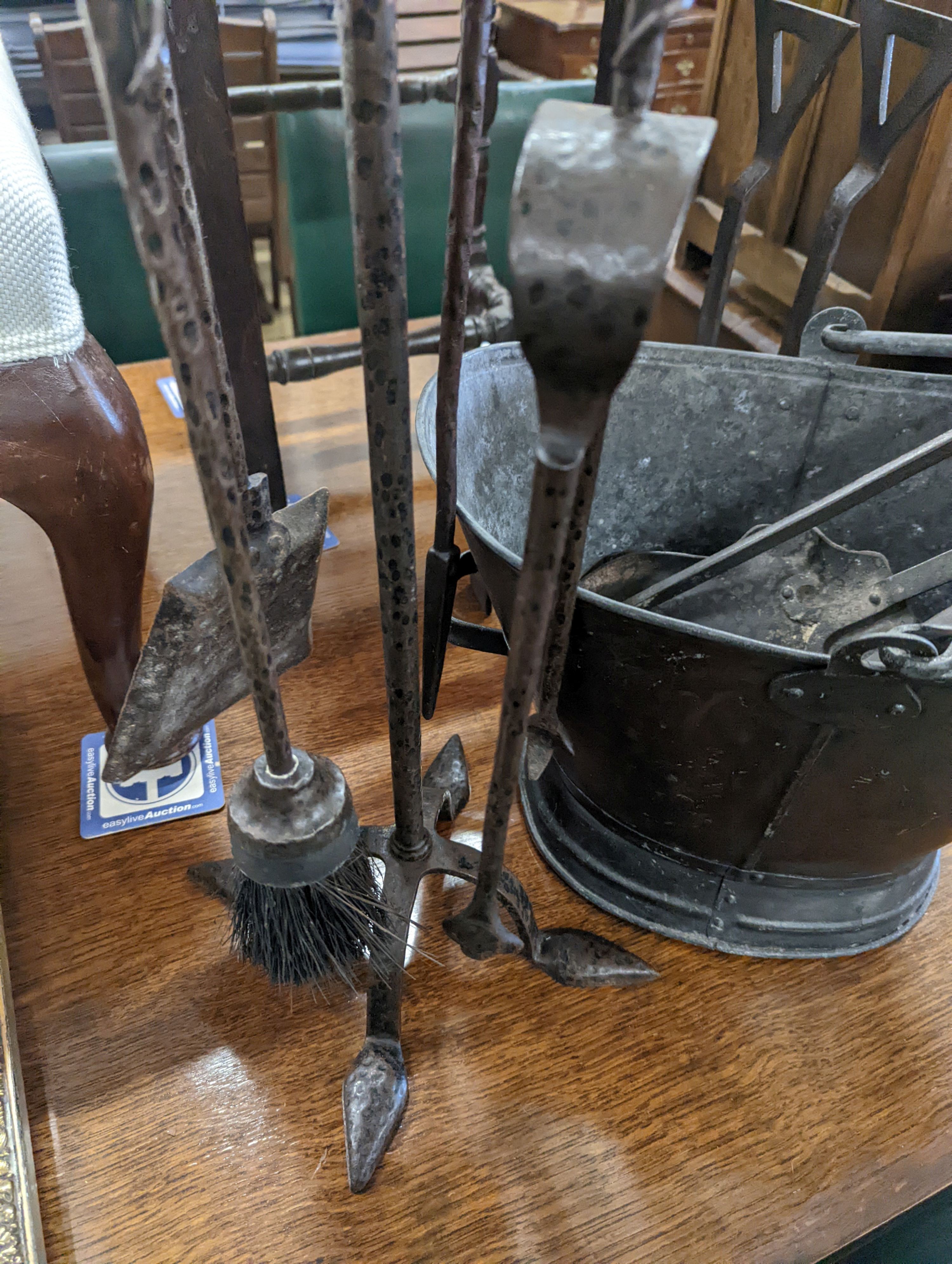 Two sets of wrought iron fire implements, a coal bucket and a pair of dogs